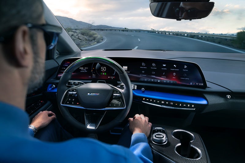 Front View of the 2026 OPTIQ-V Driving Through the Dusk Utilizing its Headlights | DeVoe Cadillac in Naples FL