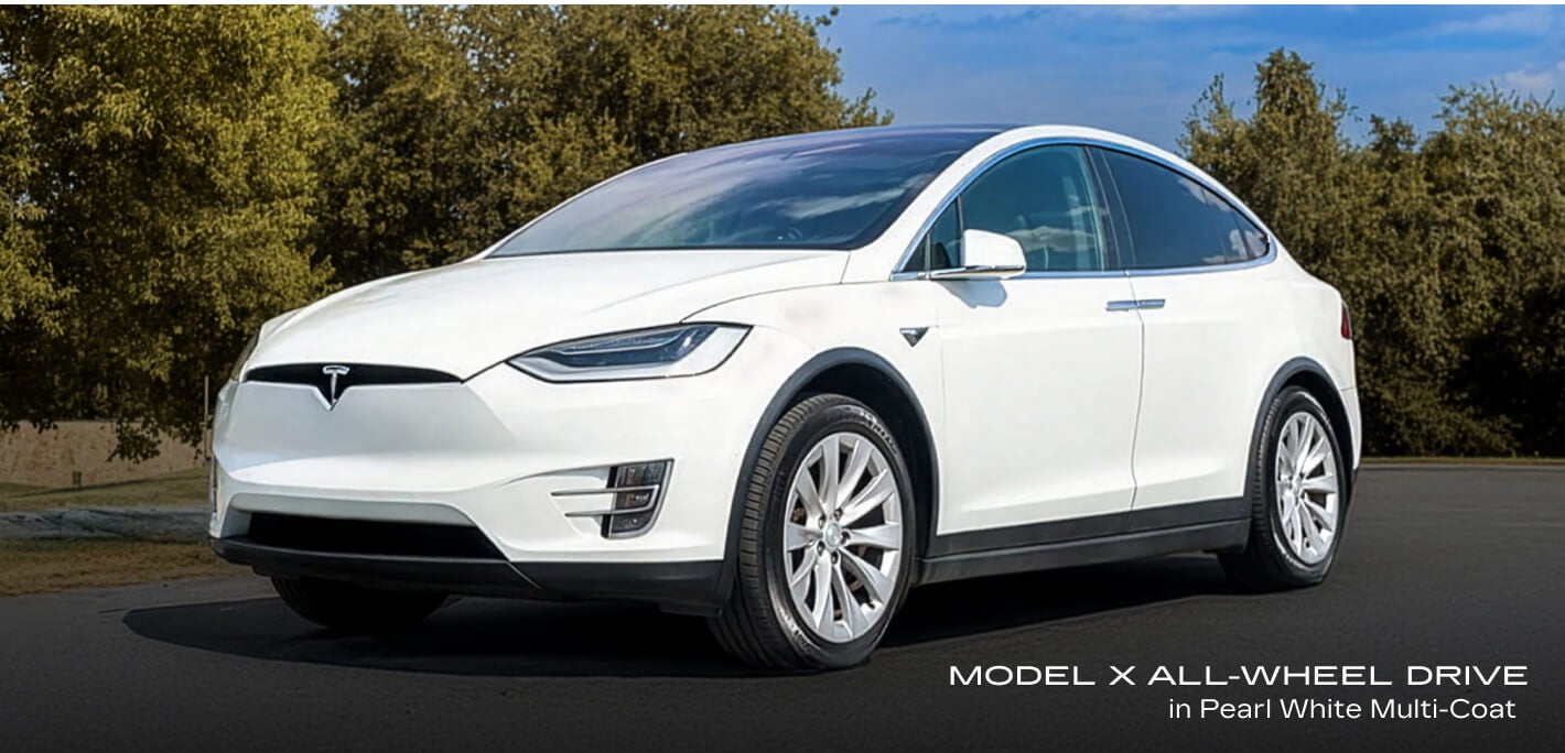 Front-three-quarter view of a Tesla Model X All-Wheel Drive in Pearl White Multi-Coat parked on an asphalt lot.