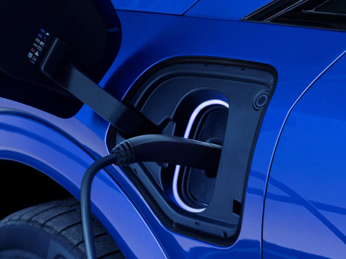 A close-up of a blue OPTIQ-V charging port with the charger plugged in.