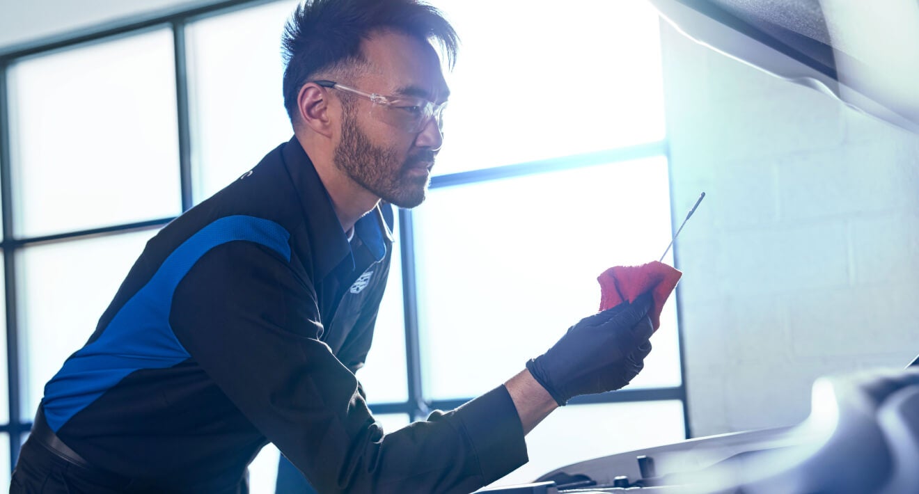 Cadillac Automotive Specialist working on vehicle windshield